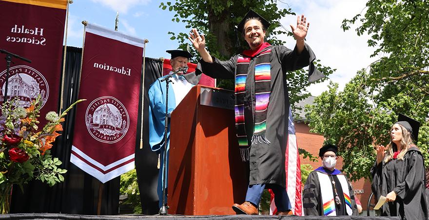 A happy male student crosses the stage at 好的赌博软件推荐